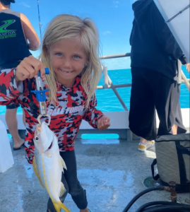 little girl holding fish on cora beth party boat.